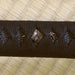 Cricket themed menuki beneath the hinerimaki black cotton wrapping