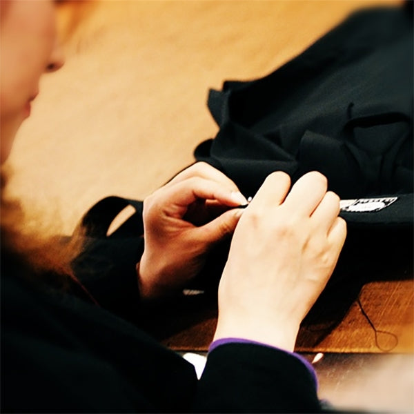One of our Heian Tailors hand-sewing the koshi-ita of a pair of hakama.