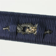 The dragon themed menuki held in the ikkan maki wrapping.