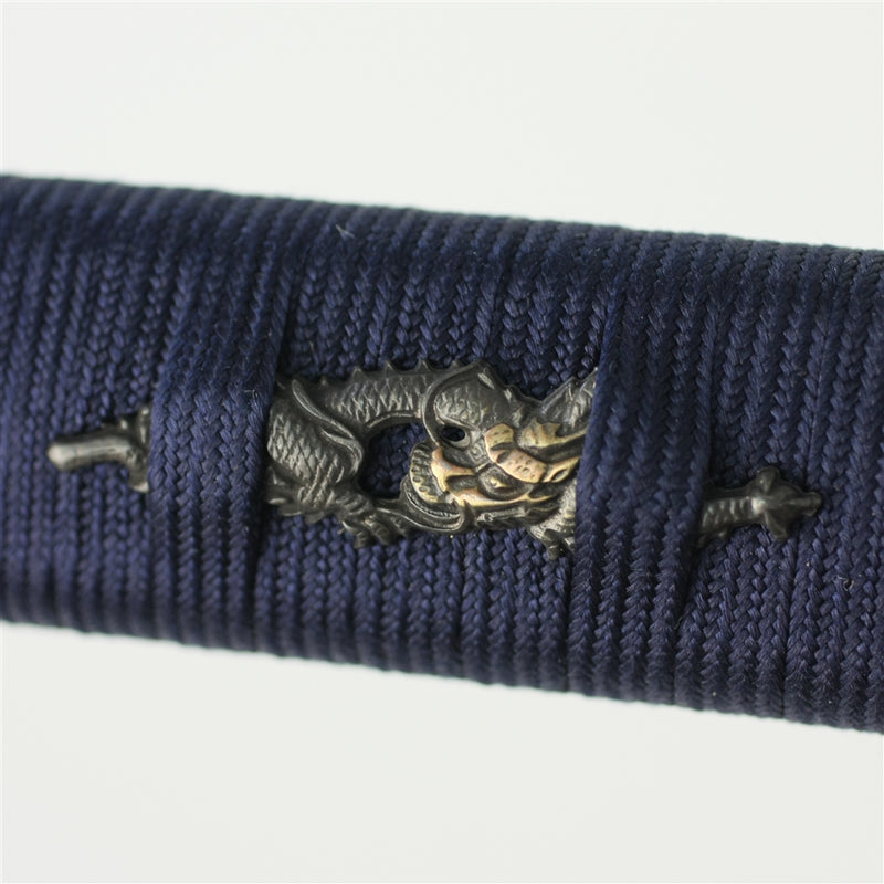 The dragon themed menuki held in the ikkan maki wrapping.