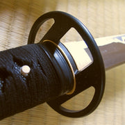 The simple black brass fuchi and tsuba seen from the ura side of the iaito.