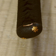 Close-up of the higo style sakura themed kashira fitting.