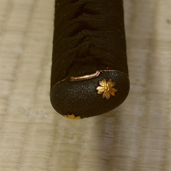 Close-up of the higo style sakura themed kashira fitting.