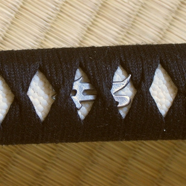 Silver-plated bonji menuki underneath the hinerimaki wrapping.
