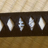 Silver-plated bonji menuki underneath the hinerimaki wrapping.