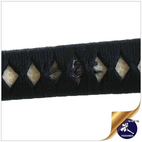 Close-up of the menuki ornaments beneath black cotton hinerimaki wrapping.