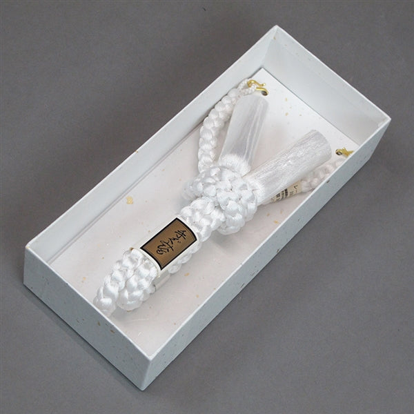 The haori himo displayed in its box.