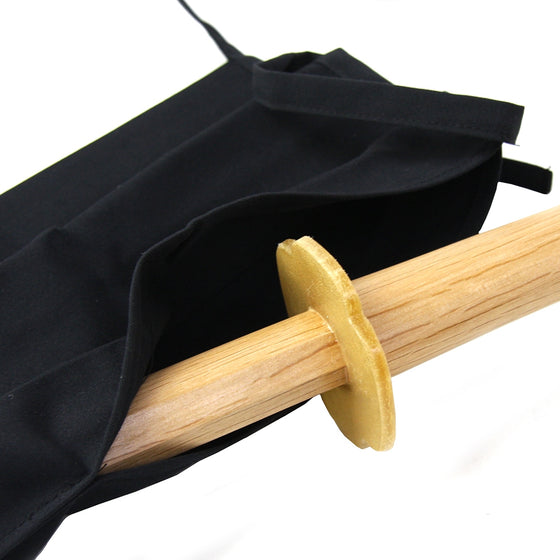 The bokuto seen being inserted into the bag with a tsuba attached.