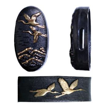 The blackened brass fuchi and kashira showing a tortoise and crane.