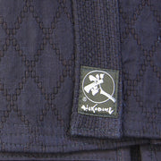 View of the double-layered dogi's hishi-zashi stiching at the bottom alongside the Tozando label.