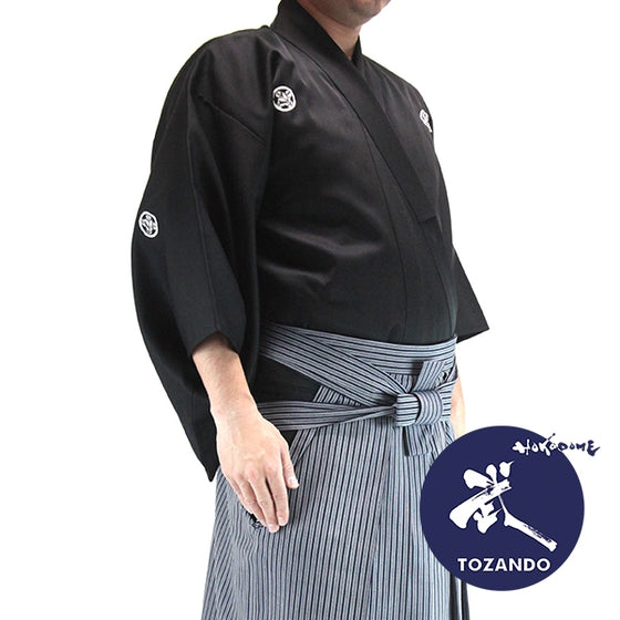 The deluxe polyester dogi with striped hakama seen from the size with Tozando logo.