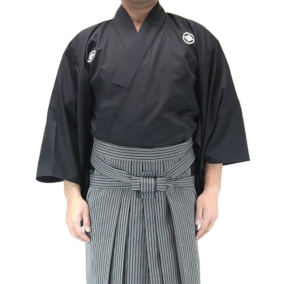 Front view of the uchimizu lightweight polyester dogi worn with the striped embu hakama.